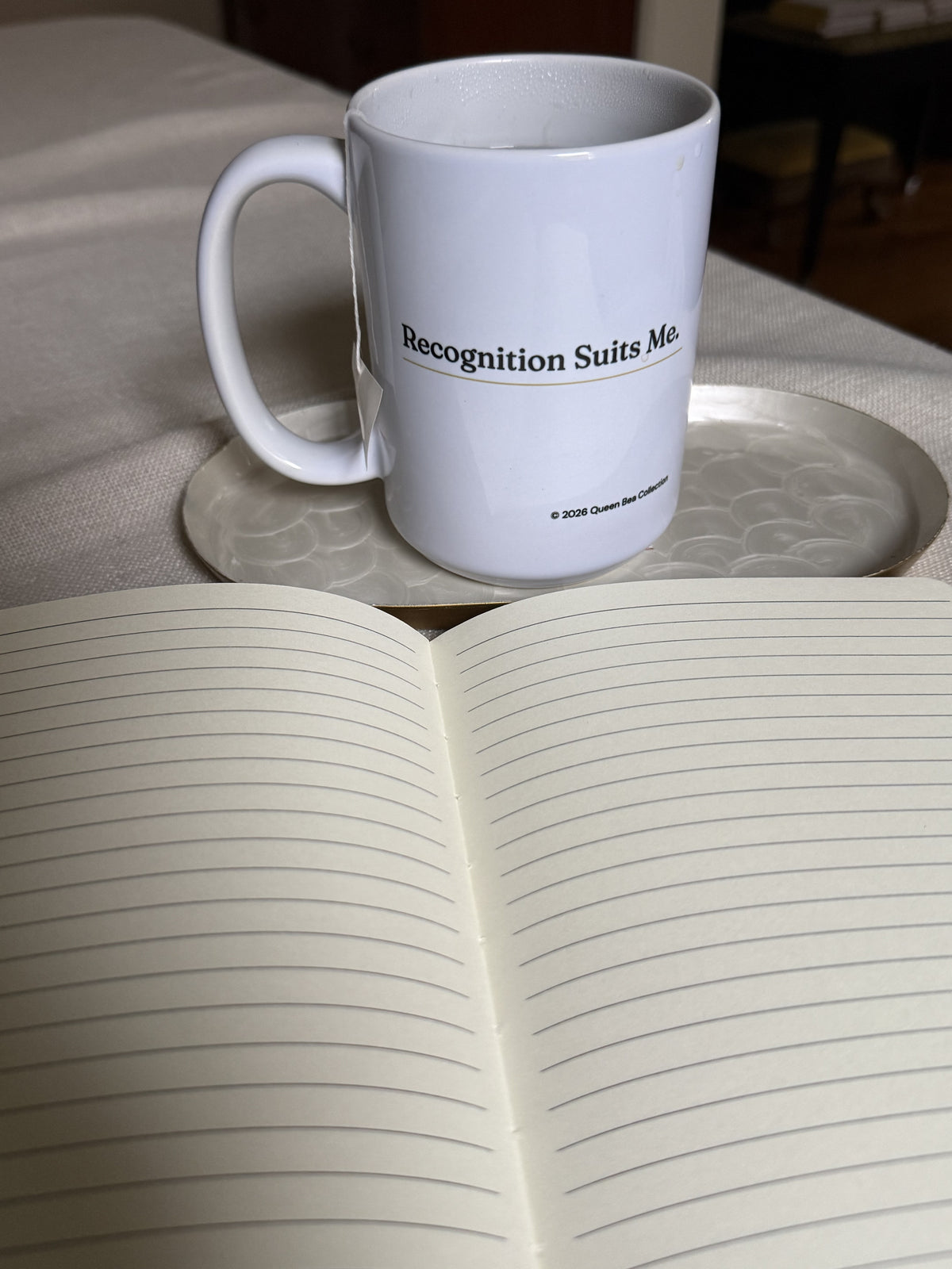 Recognition Suits Me mug beside an open journal with lined pages