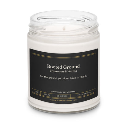 Rooted Ground soy candle in a glass jar with the black Ember & Intention label, Cinnamon & Vanilla